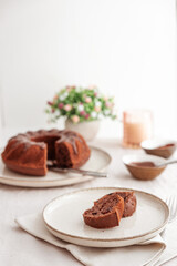 Chocolate cake with chocolate icing on white wooden table. Front view