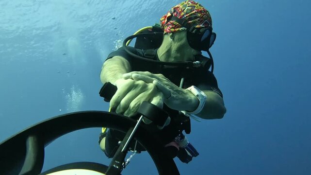 Extreme underwater hobbies. A diver rides an underwater scooter.
