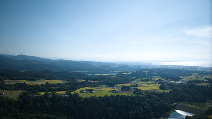 Fototapeta premium View of Toyama Bay, the Kurobe River alluvial fan, the Hokuriku Shinkansen, and farms from Kurobe City in eastern Toyama Prefecture, Japan
