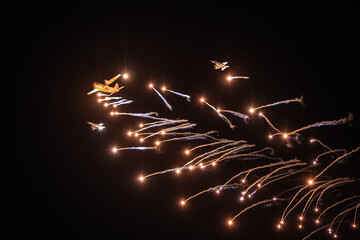 Bucharest Air Show. Evening aviation show with spectacular moments against evening sky. Romanian air show under clear moon, fireworks and flag of Romania moments.