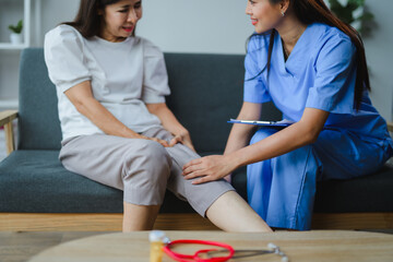Doctor examining patient's knee during home visit