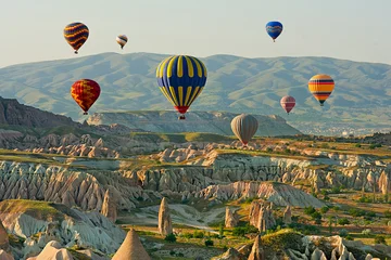 Colorful hot air balloons flying over the valley at Cappadocia, Anatolia, Turkey. Volcanic mountains in Goreme national park. © olenatur