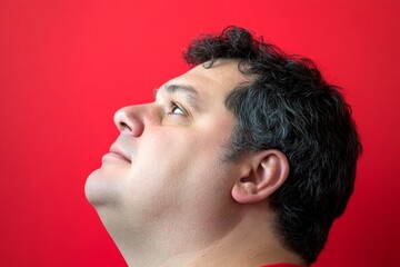 Red solid background. Visual design idea of style for aging men. A soft and natural man with a glowing expression. Chic men's mid fade haircut - midlife white man with black hair.