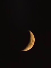 A crescent moon glows softly in the night sky, a celestial wonder