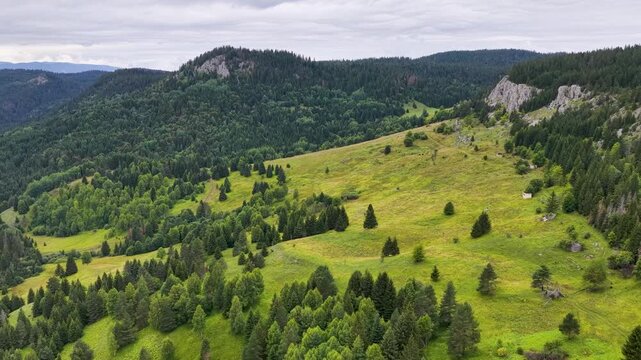 Drone view of Kasindol valley with green fields, dense forests, and surrounding mountain ridges