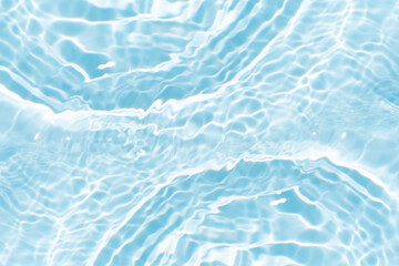 Blue water with ripples on the surface. Defocus blurred transparent blue colored clear calm water surface texture with splashes and bubbles. Water waves with shining pattern texture background.