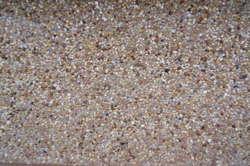 Close up of natural rough sand texture. Small beige and brown granules reveal detailed pattern. Earthy material provides versatile background
