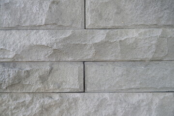 Natural light grey stone wall texture creates calming background. Rough white rock blocks form seamless pattern, ideal for architecture material