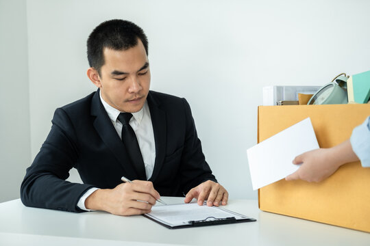 Business woman employee putting the brown cardboard box on the table and sending a letter of resignation