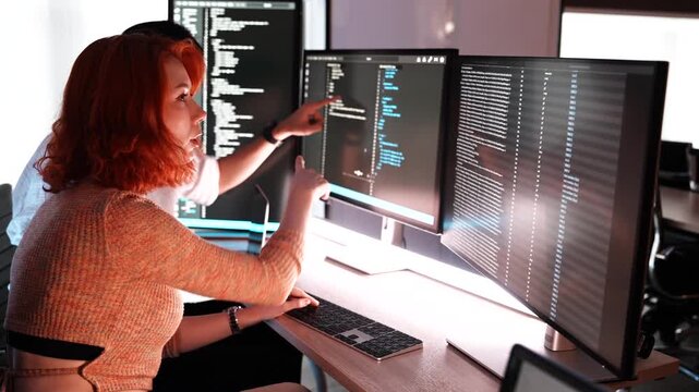 Female programmer is coding a hologram at night, working on data analytics, information technology, malware, or software at the office. Staff developer work in a computer display in problem solving.