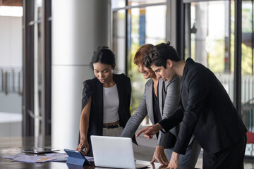 Conversation or group discussion among business team members from different generations, cultures, and diverse ethnicities outside of the main office. Group of people use computer to get information