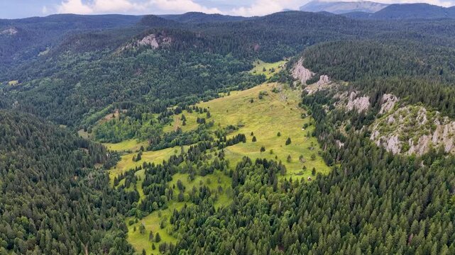Drone view of Kasindol valley and surrounding mountains with forested slopes
