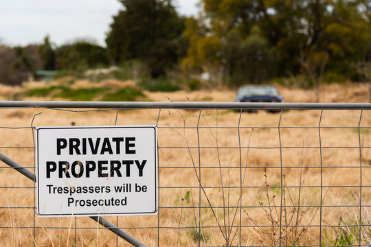 private property sign on fence with &ldquo;trespassers will be prosecuted&rdquo; text
