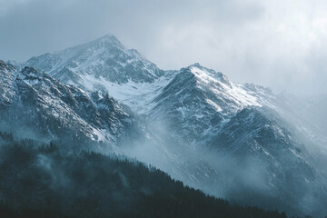 Obraz premium Foggy alpine scene with snow-covered mountains, ideal for travel, adventure, and nature themes.
