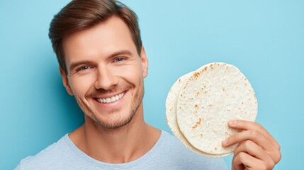 A studio photo of a smiling man with brown hair, dressed in a light shirt, showcases a flatbread in a casual setting, evoking a friendly emotion, and emphasizing a culinary use and baking product for