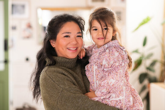 mother holding her young daughter in her arms