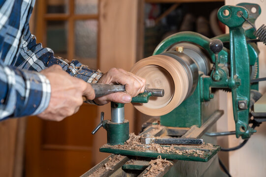 Carpentry. Turnery of a wooden bowl with spiral sawdust shavings with hand and chisel. High quality photography