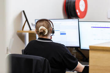 female administrate staff lady sitting by computer at front desk office
