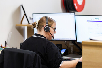 female administrate staff lady sitting by computer at front desk office