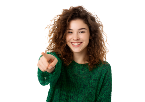 Smiling curly haired woman in green pointing at camera on white background