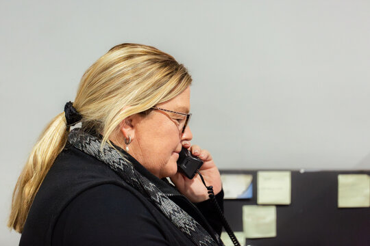 Female front desk staff lady on telephone call inside office