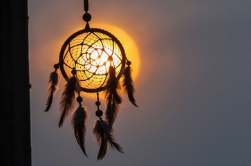 A beautifully decorated Native American dreamcatcher hanging against a golden sunset sky, feathers and beads swaying gently in the breeze, symbolizing protection, spiritual connection