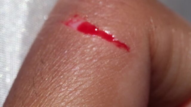 Footage of a brown-skinned man's bleeding index finger. Close-up motion videography of an injured finger. Workplace accident. Blood flowing motion. High Quality 4K Resolution