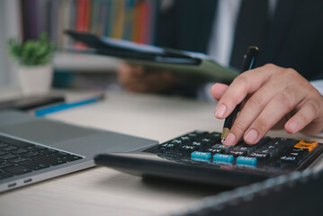 Business executive working with calculator, pen and document file, accounting service, financial management, tax report, company budget planning, audit process and economic analysis.