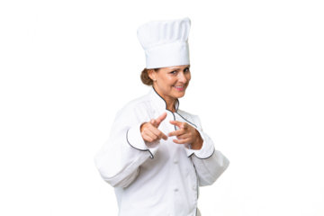 Middle-aged chef woman over isolated background pointing to the front and smiling
