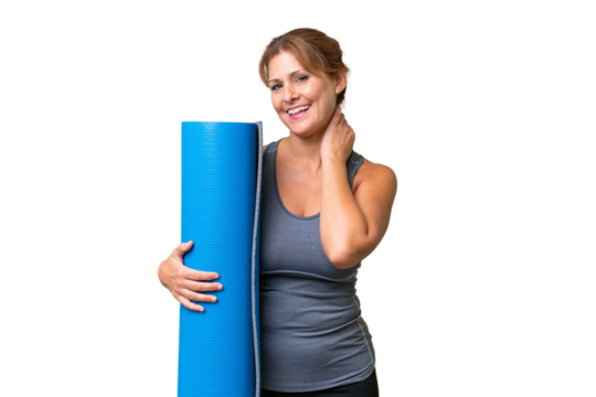 Middle-aged sport woman going to yoga classes while holding a mat over isolated background laughing - Powered by Adobe