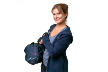 Middle-aged sport woman with sport bag over isolated background with arms crossed and looking forward