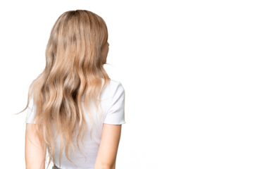 Young English woman over isolated background in back position and looking back