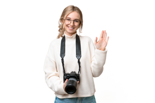 Young photographer English woman over isolated background saluting with hand with happy expression