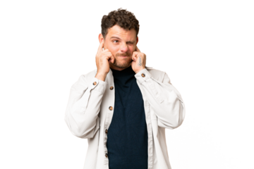 Brazilian man over isolated chroma key background frustrated and covering ears