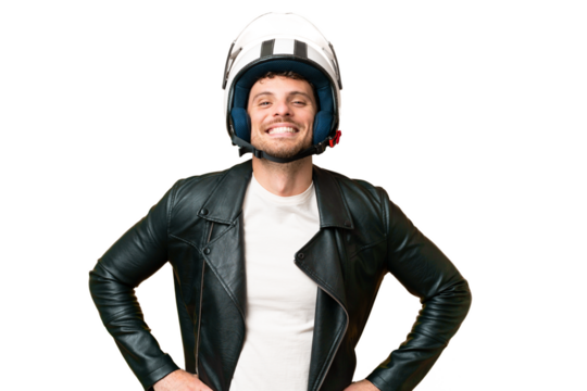 Brazilian man with a motorcycle helmet over isolated chroma key background posing with arms at hip and smiling