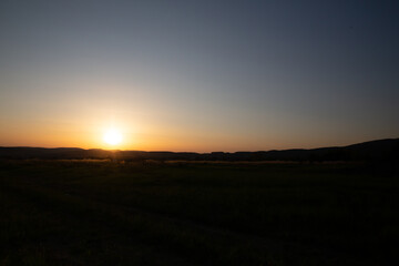 The sun dips below the horizon, painting the sky with vibrant colors during dusk.