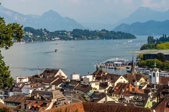 Panoramic photo of red roofs of old town of Lucern with a view od the lake and mountains in the background