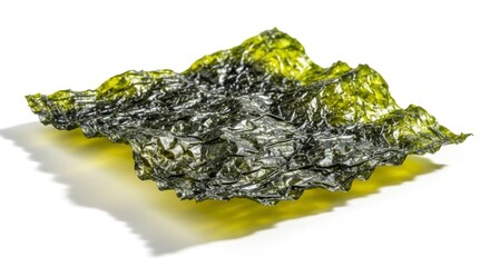 Single sheet of textured dried seaweed with a golden hue casting a shadow on a white surface