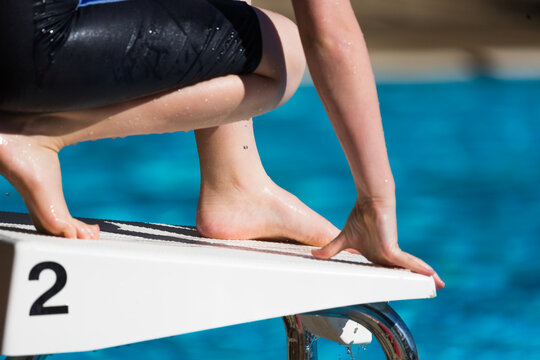 young swimmer on a block with the number 2