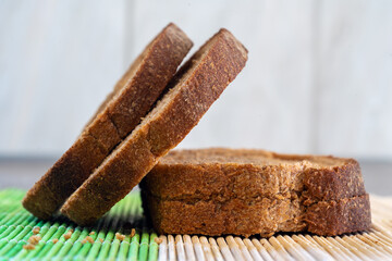A close-up view of the rich texture of sliced rye or whole wheat bread. This image is ideal for illustrating the benefits of a fiber-rich diet, healthy carbohydrates, and homemade baking.
