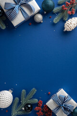 Fototapeta na wymiar Festive vertical Christmas composition featuring wrapped presents, decorations, and ornaments on a navy surface