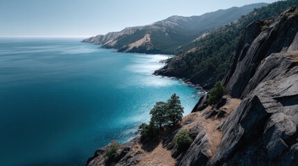 Obraz premium A vast expanse of azure ocean meets dramatic, dark cliffs in a serene coastal landscape.