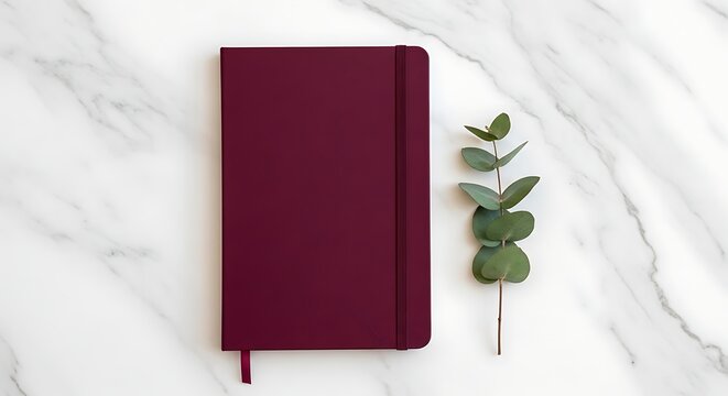 Elegant deep red notebook for daily thoughts or work planning, beautifully presented on marble