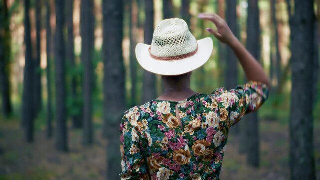 Traveler Wearing Straw Hat  Walking Among Tall Trees In Pine Forest. Eco Tourism. Exploration Tranquil Woodland