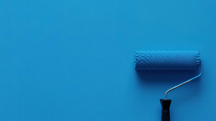 Paint roller with black handle coated in blue paint on smooth surface, home improvement flatlay