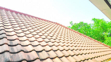 The clay tile roof shields the house from extreme weather with sky background