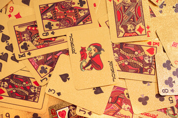 A scattered collection of playing cards covers a surface, displaying various suits and numbers in a casual arrangement.