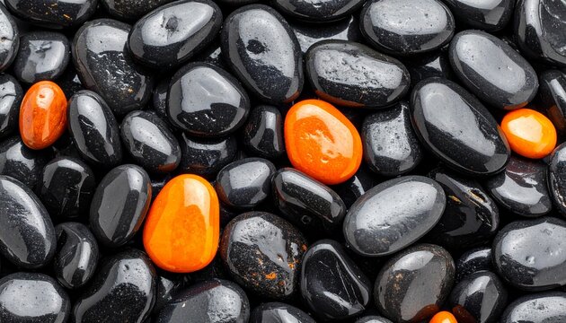 A mesmerizing collection of polished black river stones with vibrant orange pebbles creating a striking visual contrast and a sense of calm and individuality