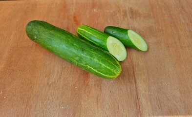cucumbers on a wooden background,fresh whole cucumber  and fresh sliced cucumber