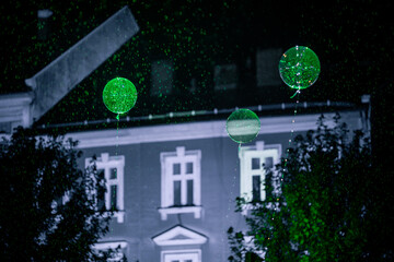 Zielone podświetlone balony, kule nad budynkiem nocą © Adam.rtk
